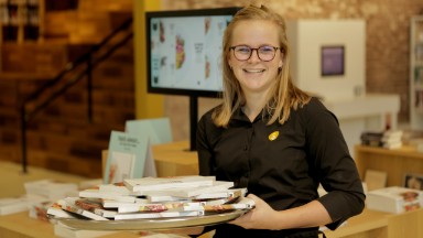 vrouw met kind tussen de boeken